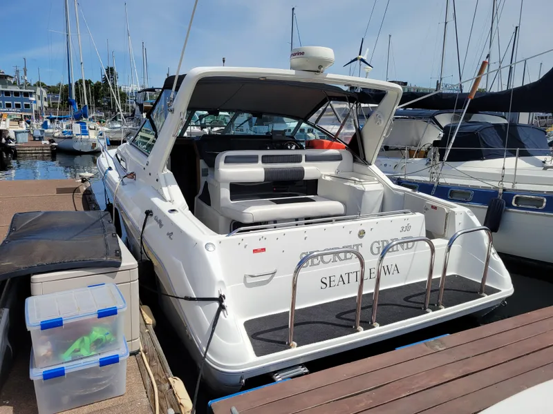 Slide: The Image of 1992 Sea Ray 330 Sundancer docked at marina, Seattle, WA, with open cockpit and seating. - 4