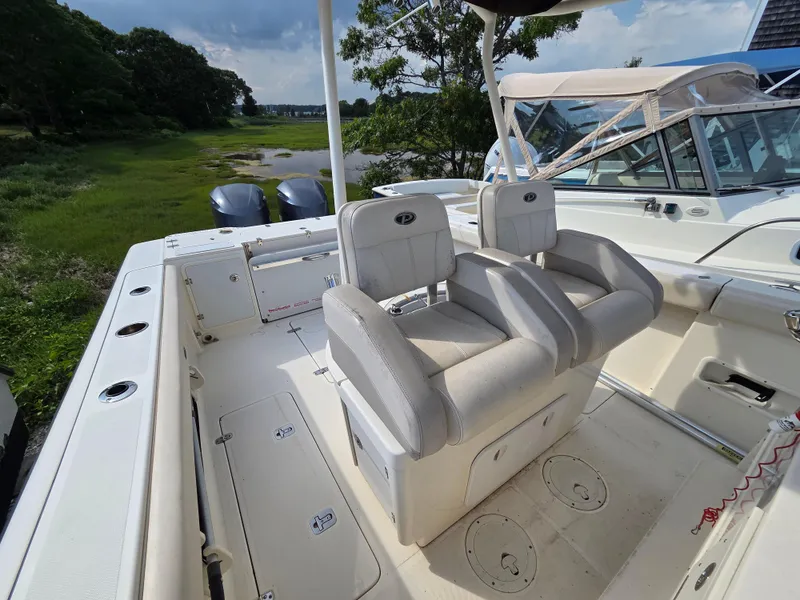 Slide: The Image of 2014 Pursuit C 280 Center Console boat interior with dual seats and storage compartments. - 9