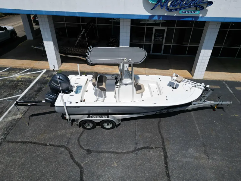 Slide: The Image of 2018 Tidewater 2110 Baymax boat on trailer, parked outside a marine dealership. - 3