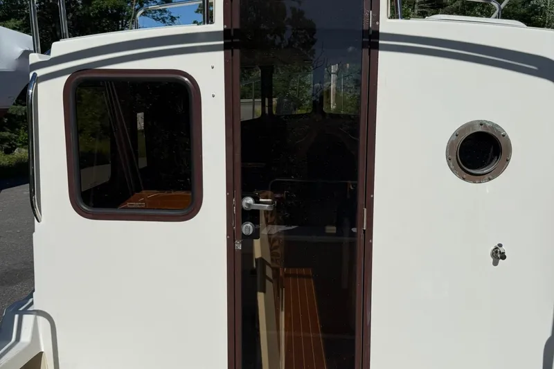 Slide: The Image of 2010 Ranger Tugs R-25 boat cabin entrance with porthole and glass door. - 10