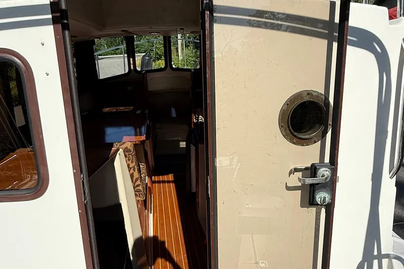 Slide: The Image of Interior view of 2010 Ranger Tugs R-25 boat, featuring wooden flooring and seating. - 11