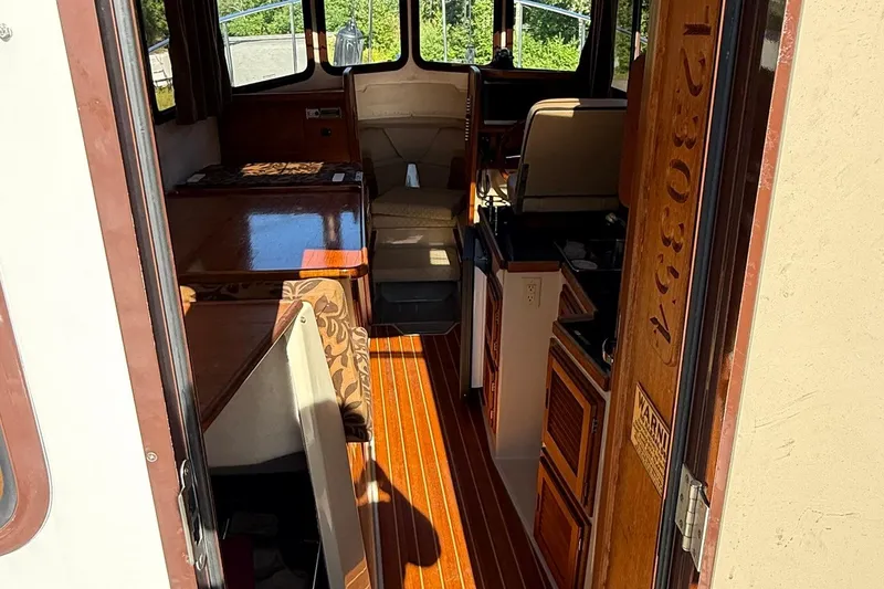 Slide: The Image of Interior of 2010 Ranger Tugs R-25 boat with wood flooring and seating area. - 12