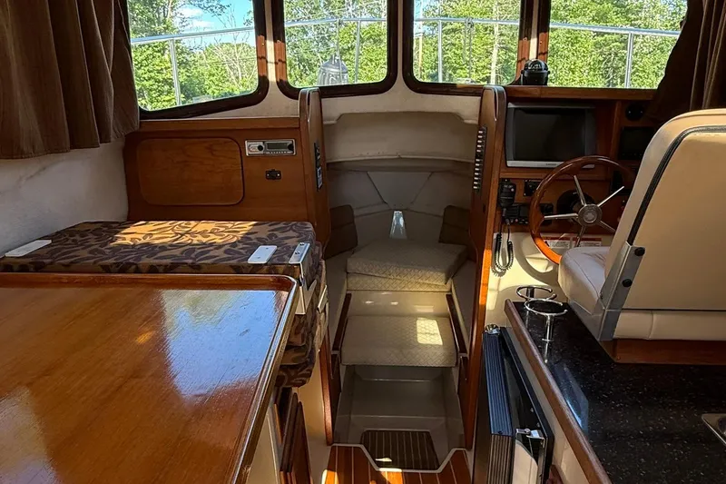 Slide: The Image of Interior of 2010 Ranger Tugs R-25 boat with wood finishes and steering wheel. - 14