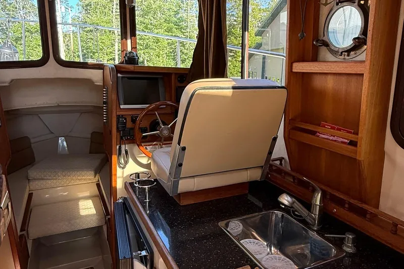 Slide: The Image of Interior of 2010 Ranger Tugs R-25 boat with helm, seating, and kitchenette. - 15