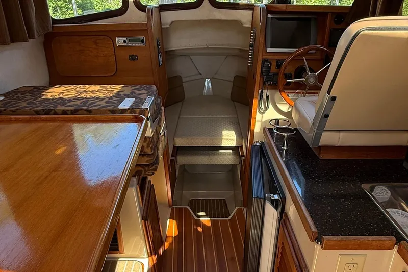 Slide: The Image of Interior of 2010 Ranger Tugs R-25 boat with wood accents and seating area. - 16