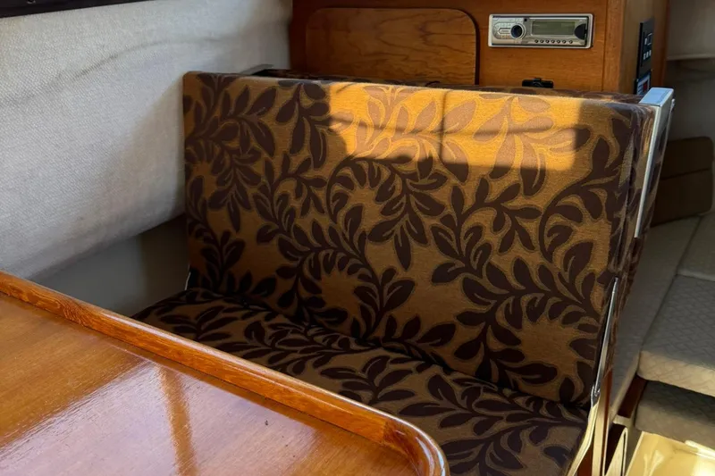 Slide: The Image of 2010 Ranger Tugs R-25 interior with patterned upholstery and wooden accents. - 19