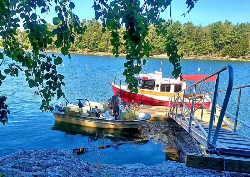 Slide: The Image of Boats docked by a scenic lake, featuring a 2010 Ranger Tugs R-25. - 2