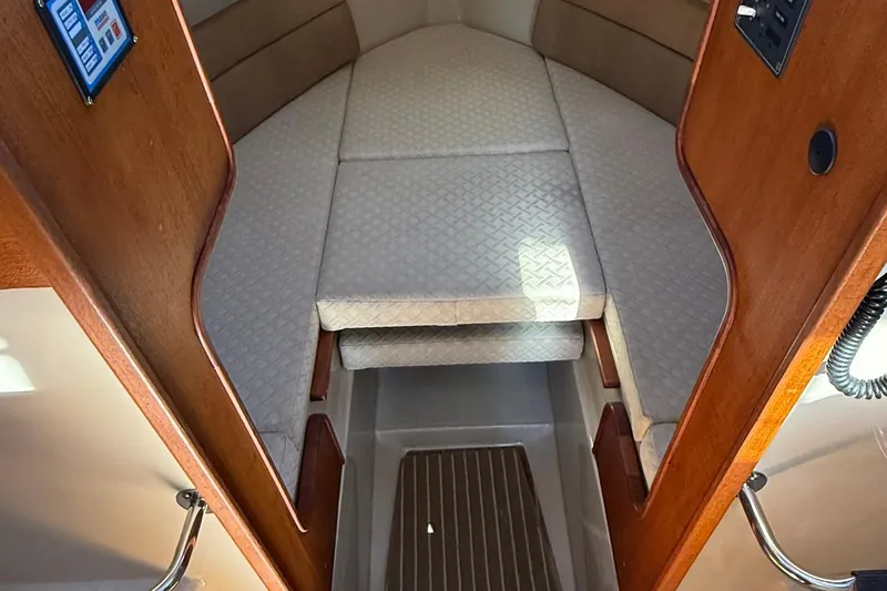 Slide: The Image of 2010 Ranger Tugs R-25 cabin interior with cushioned seating and wooden accents. - 21