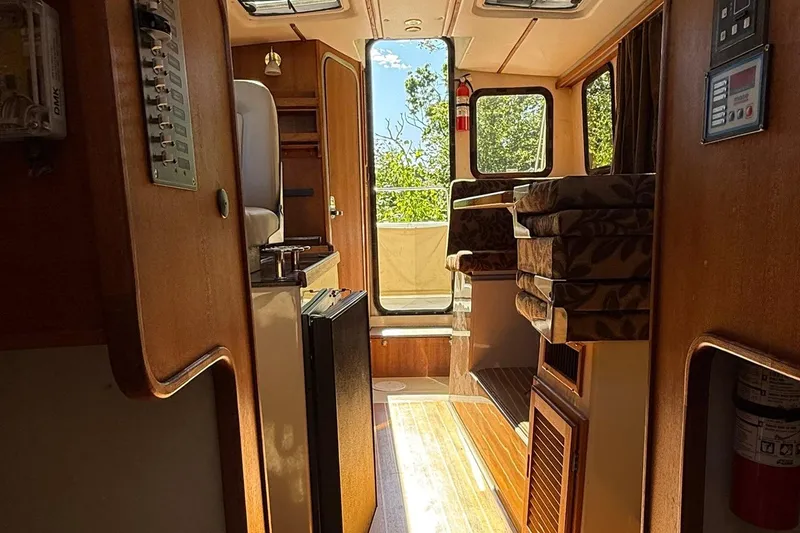 Slide: The Image of Interior of 2010 Ranger Tugs R-25 boat, featuring wood paneling and seating area. - 22