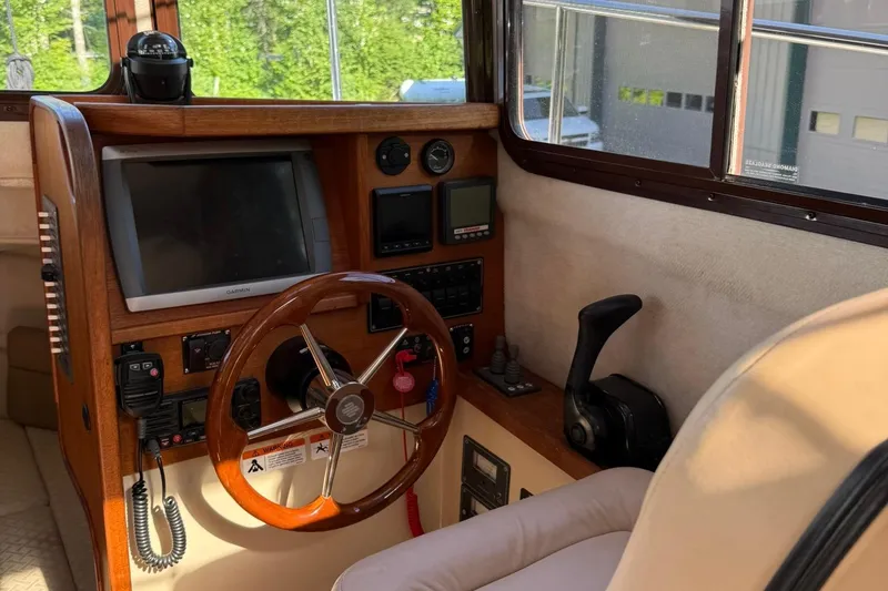 Slide: The Image of Interior helm of 2010 Ranger Tugs R-25 with wooden steering wheel and navigation equipment. - 25