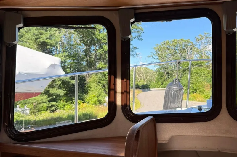 Slide: The Image of Interior view from a 2010 Ranger Tugs R-25, showing windows and outdoor scenery. - 28