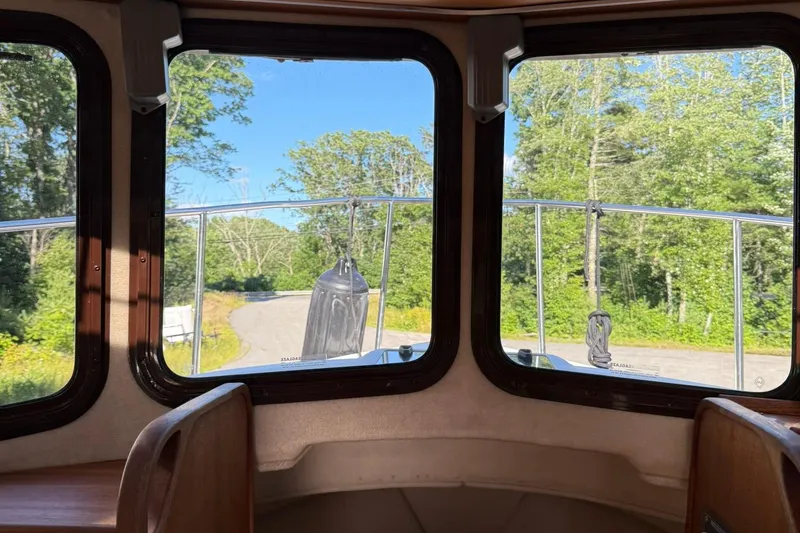 Slide: The Image of Interior view from a 2010 Ranger Tugs R-25, showcasing windows and scenic greenery. - 29
