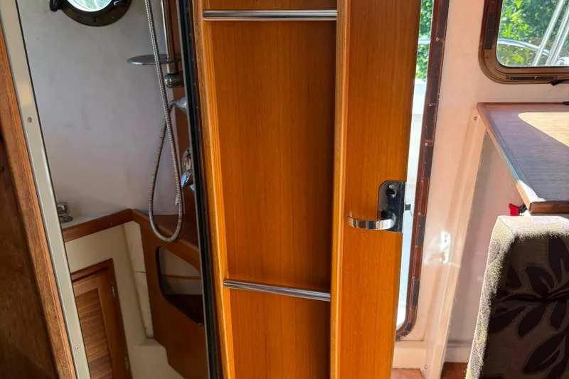 Slide: The Image of Interior of 2010 Ranger Tugs R-25 boat showing wooden cabinetry and shower area. - 38