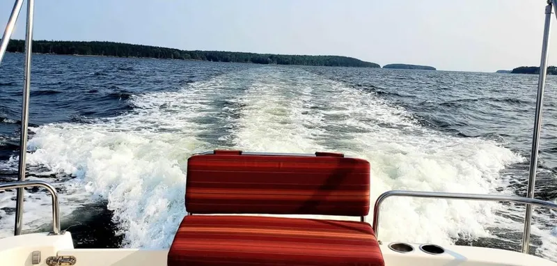 Slide: The Image of Ranger Tugs R-25 boat cruising on a lake, leaving a wake behind, 2010 model. - 4