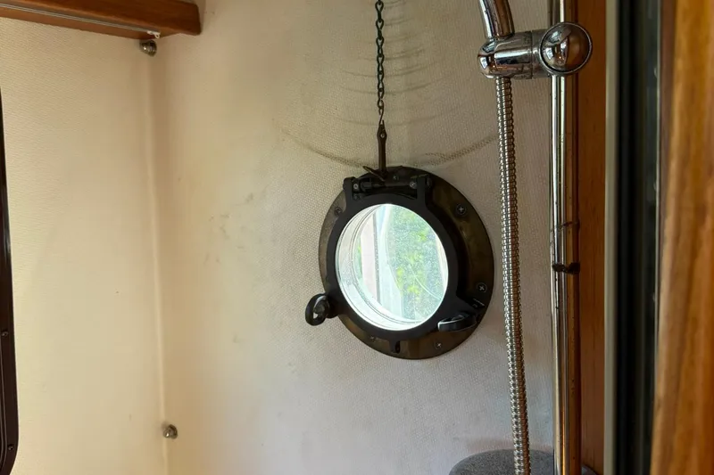 Slide: The Image of Porthole and shower fixture inside 2010 Ranger Tugs R-25 boat cabin. - 43