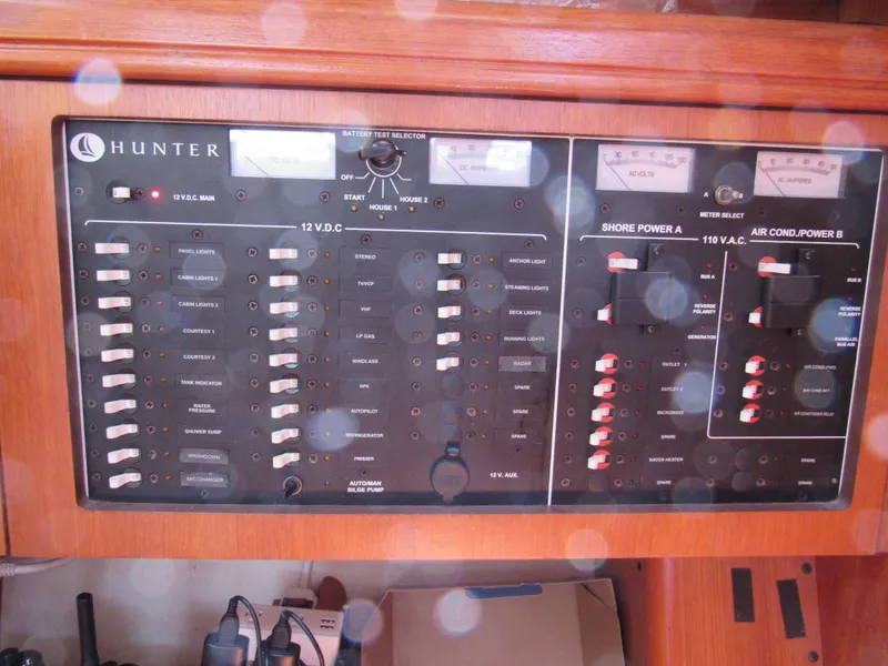 Slide: The Image of Electrical control panel on a 2002 Hunter 466 yacht, featuring various switches and meters. - 14