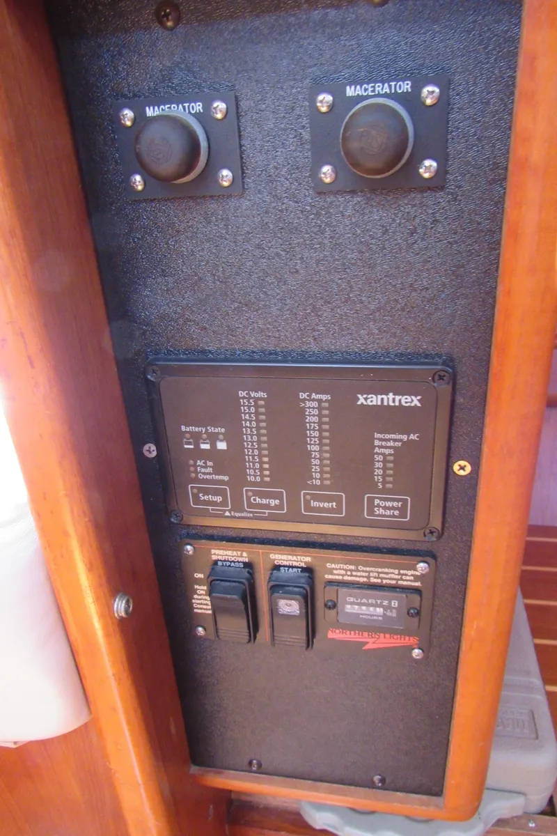 Slide: The Image of Electrical control panel on a 2002 Hunter 466 boat, featuring Xantrex system and macerator switches. - 15