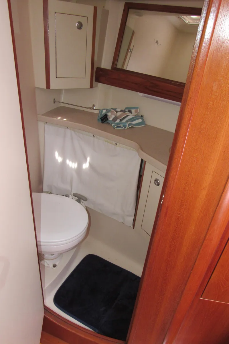Slide: The Image of Compact bathroom in 2002 Hunter 466 yacht with toilet, sink, and mirror. - 17