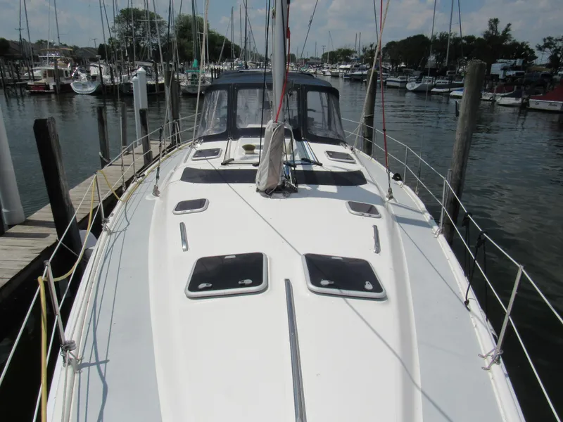 Slide: The Image of Sailboat docked at marina, Hunter 466 model, 2002, with visible deck and rigging. - 2