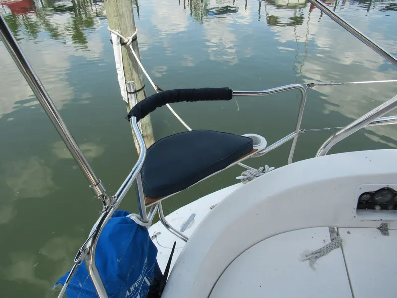 Slide: The Image of Hunter 466 sailboat stern with seating, docked by calm water, 2002 model. - 24