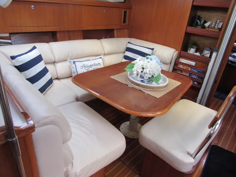 Slide: The Image of Cozy interior of 2002 Hunter 466 yacht with cushioned seating and decorative pillows. - 6