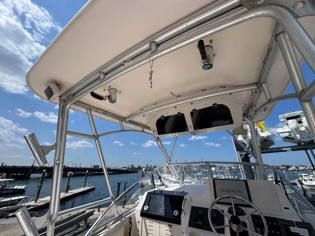 Slide: The Image of 2003 Grady-White Sailfish 282 boat helm with electronics, docked at marina under blue sky. - 10