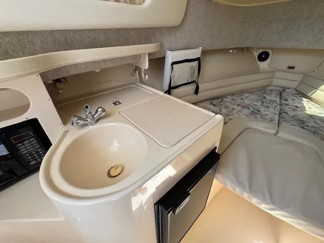 Slide: The Image of 2003 Grady-White Sailfish 282 cabin interior with sink, countertop, and sleeping area. - 14