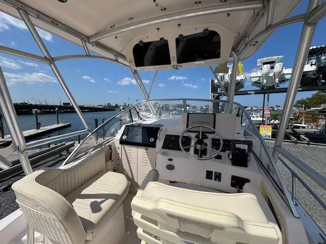 Slide: The Image of 2003 Grady-White Sailfish 282 boat cockpit with steering wheel and seating, dockside view. - 9