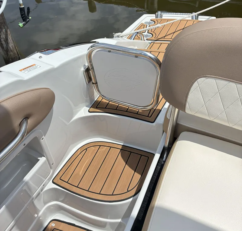 Slide: The Image of 2022 Crownline Eclipse E235 XS boat interior with teak flooring and cushioned seating. - 16