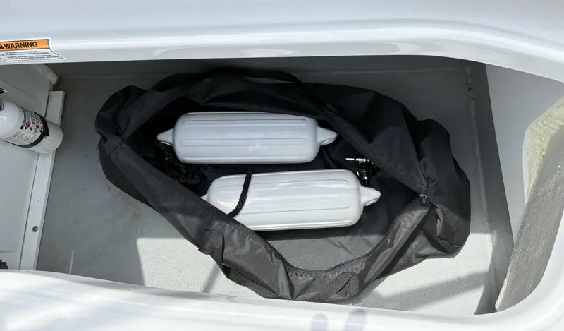 Slide: The Image of Storage compartment in 2022 Crownline Eclipse E235 XS with fenders and fire extinguisher. - 20