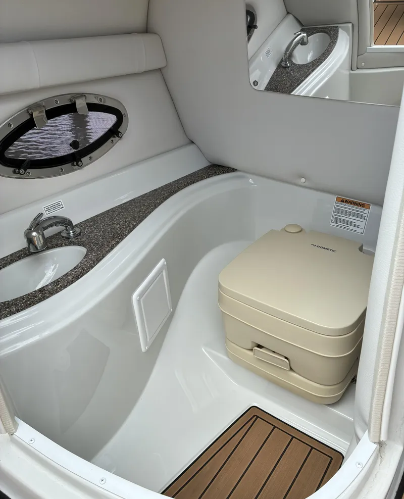 Slide: The Image of 2022 Crownline Eclipse E235 XS boat interior with sink and portable toilet. - 8