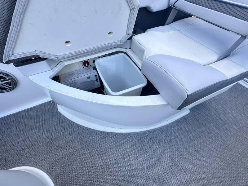 Slide: The Image of 2016 Formula 240 Bowrider storage compartment with white seating and gray carpet. - 11