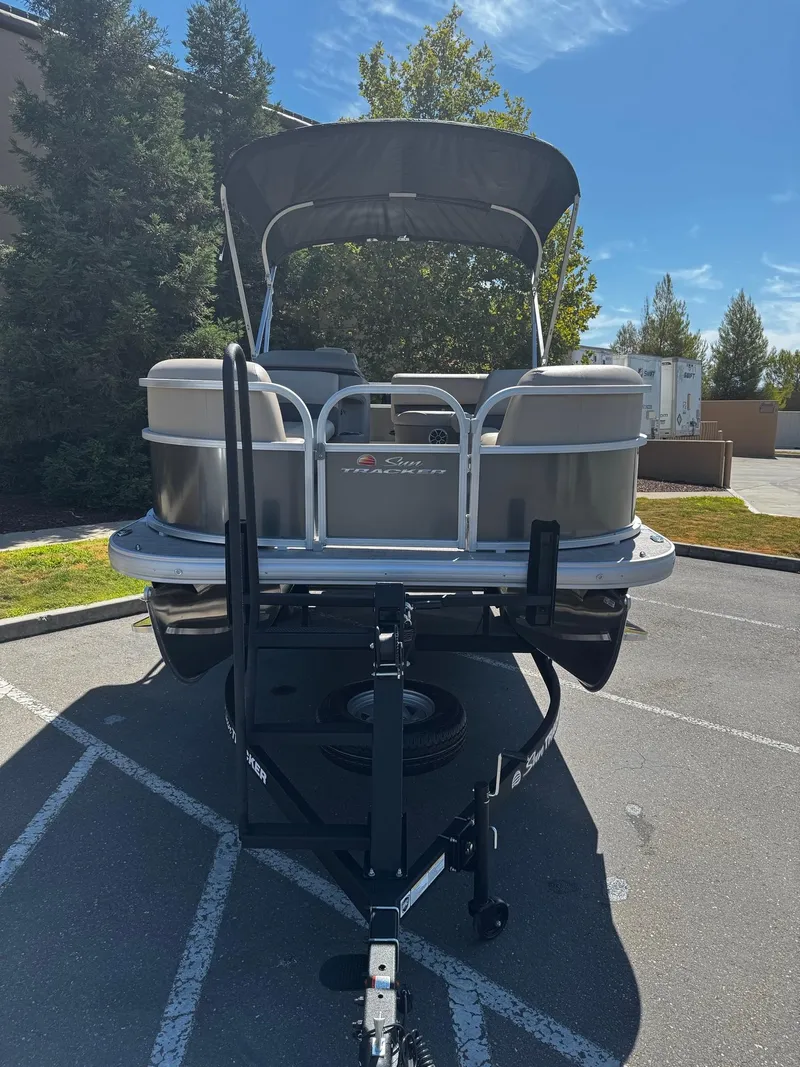 Slide: The Image of 2025 Sun Tracker Party Barge 18 DLX pontoon boat on trailer in parking lot. - 4