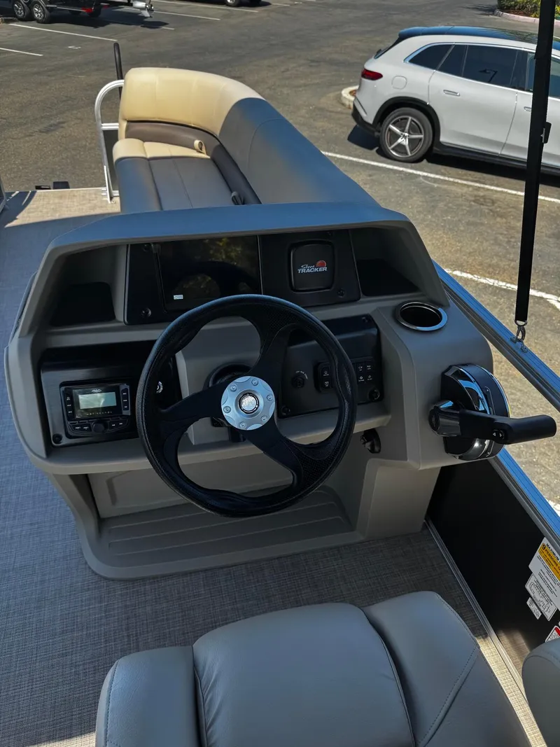 Slide: The Image of 2025 Sun Tracker Party Barge 18 DLX steering console with modern controls and seating. - 6