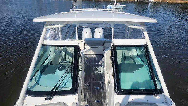 Slide: The Image of 2024 Pursuit DC 266 Dual Console boat on calm water, showcasing sleek design and spacious interior. - 11