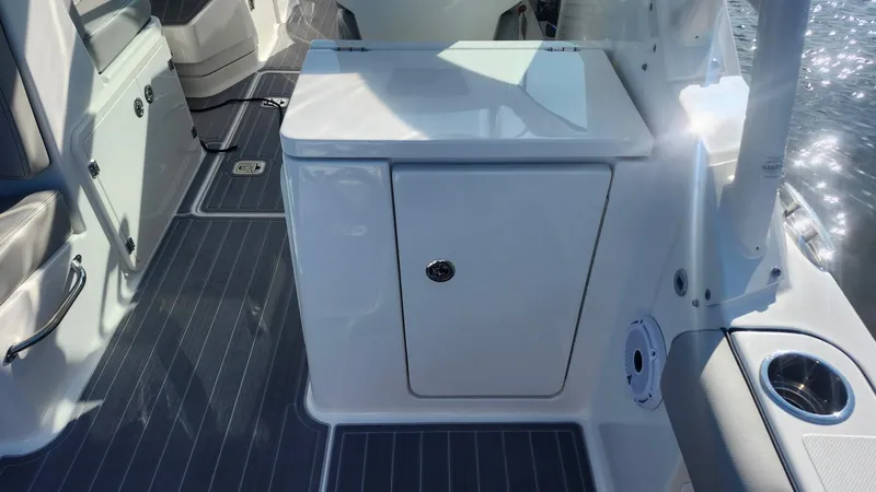 Slide: The Image of 2024 Pursuit DC 266 Dual Console boat interior with storage compartment and sleek design. - 15