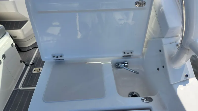 Slide: The Image of 2024 Pursuit DC 266 Dual Console boat sink and storage area. - 17