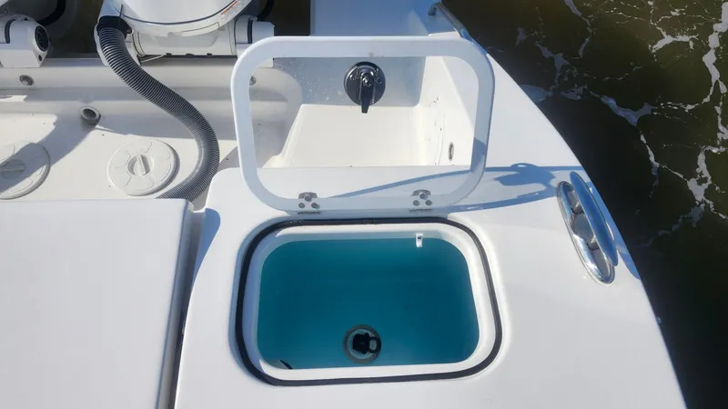Slide: The Image of 2024 Pursuit DC 266 Dual Console boat with open livewell, showcasing sleek design and functionality. - 18