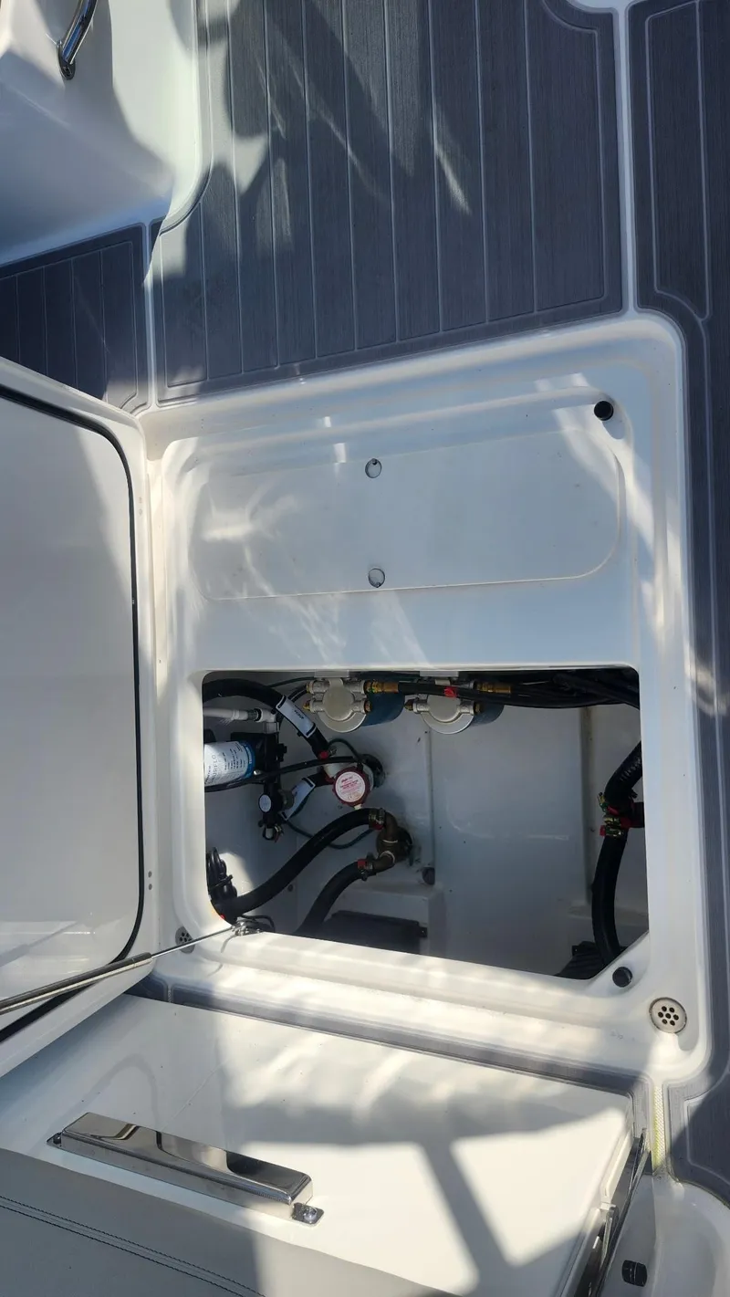 Slide: The Image of 2024 Pursuit DC 266 Dual Console boat compartment with visible wiring and components. - 24