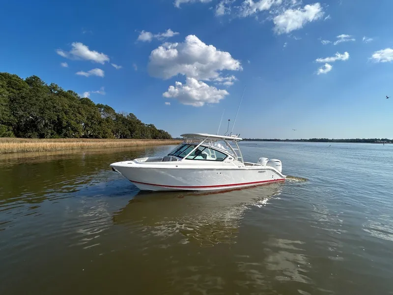 Slide: The Image of 2024 Pursuit DC 266 Dual Console boat on calm water under blue sky. - 27