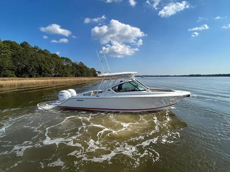 Slide: The Image of 2024 Pursuit DC 266 Dual Console boat cruising on a sunny day with clear skies. - 33