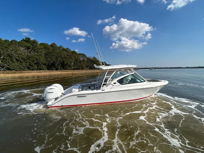 Slide: The Image of 2024 Pursuit DC 266 Dual Console boat cruising on a sunny day with clear skies. - 38
