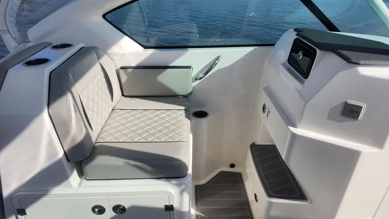 Slide: The Image of 2024 Pursuit DC 266 Dual Console interior with cushioned seating and cup holders. - 4