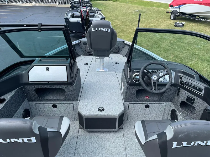 Slide: The Image of 2026 Lund 1875 Impact XS Sport boat interior with steering wheel and seating. - 13