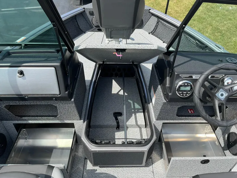 Slide: The Image of 2026 Lund 1875 Impact XS Sport boat interior with storage compartments and steering wheel. - 14