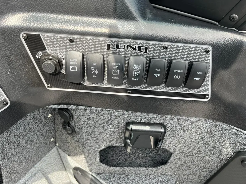 Slide: The Image of Control panel of 2026 Lund 1875 Impact XS Sport boat with various switches. - 17