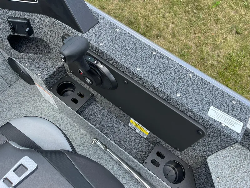 Slide: The Image of 2026 Lund 1875 Impact XS Sport boat interior with control panel and cup holders. - 19