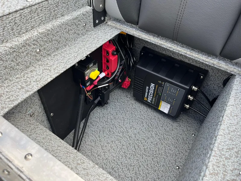 Slide: The Image of 2026 Lund 1875 Impact XS Sport boat battery compartment with Minn Kota Precision charger. - 26