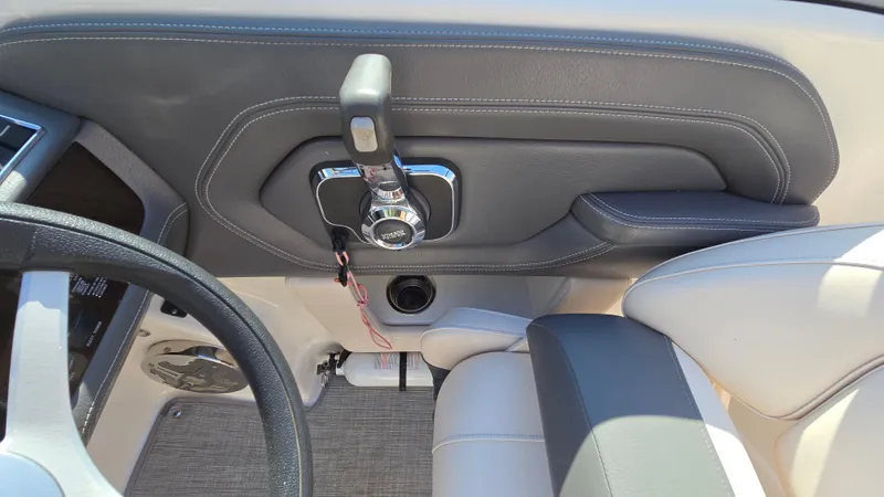 Slide: The Image of 2018 Chaparral 224 Sunesta boat interior, featuring steering wheel and throttle controls. - 38