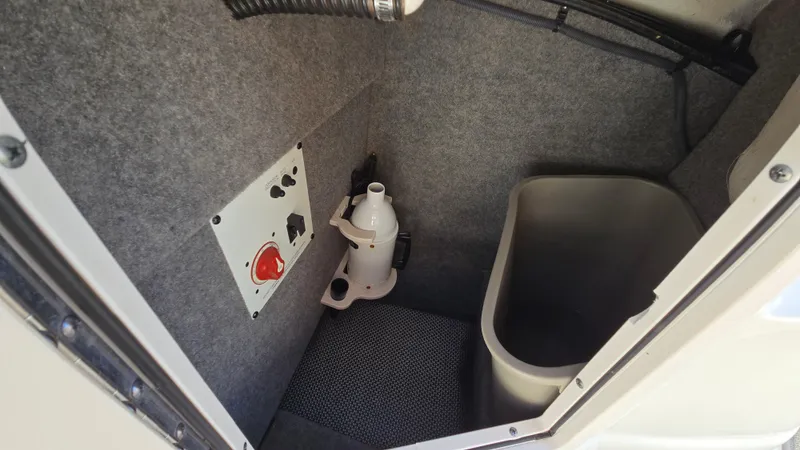 Slide: The Image of 2018 Chaparral 224 Sunesta boat interior storage compartment with utility panel and container. - 44